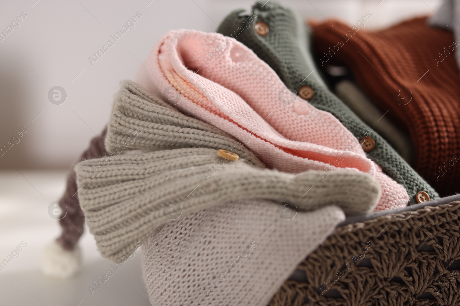 Wool baby clothes in basket on table indoors, closeup Photo of Wool baby clothes in basket on table indoors, closeup