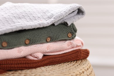 Photo of Wool baby clothes on wicker box indoors, closeup