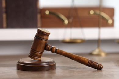 Photo of Judge. Gavel and scales on wooden table in office, selective focus
