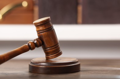 Photo of Judge. Gavel and sound block on wooden table in office, closeup