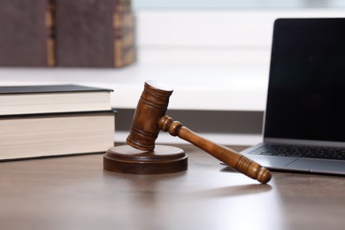 Photo of Judge. Laptop, gavel and books on wooden table in office