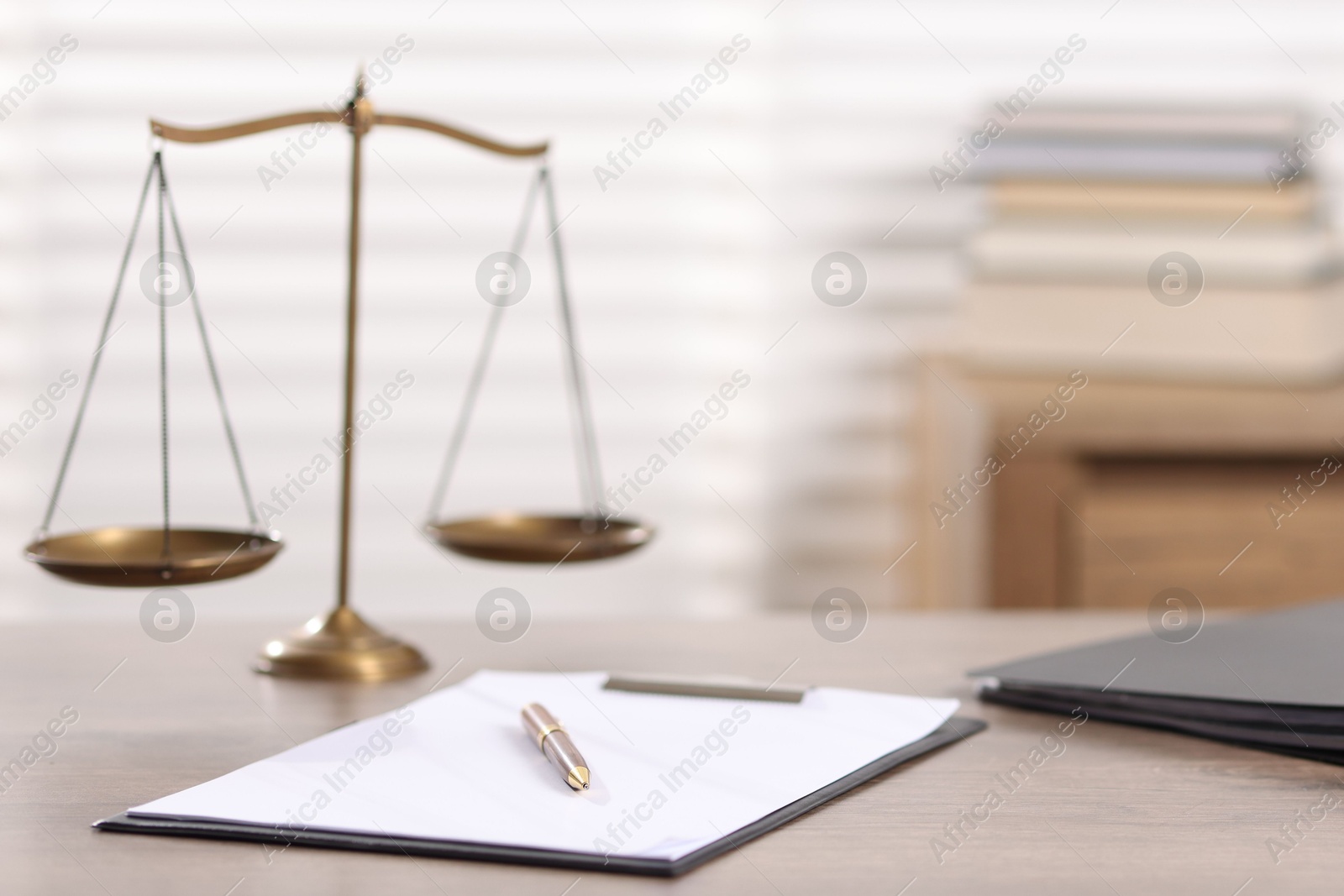 Judge. Scales, clipboard, pen and folders on wooden table in office, selective focus Photo of Judge. Scales, clipboard, pen and folders on wooden table in office, selective focus