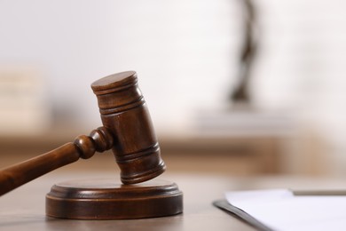 Photo of Judge. Gavel and clipboard on wooden table in office, closeup. Space for text