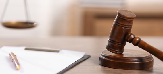 Photo of Judge. Gavel, clipboard and pen wooden table in office, closeup