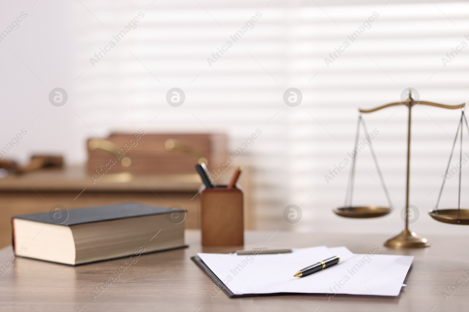Judge. Scales, book, papers and pen on wooden table in office Photo of Judge. Scales, book, papers and pen on wooden table in office