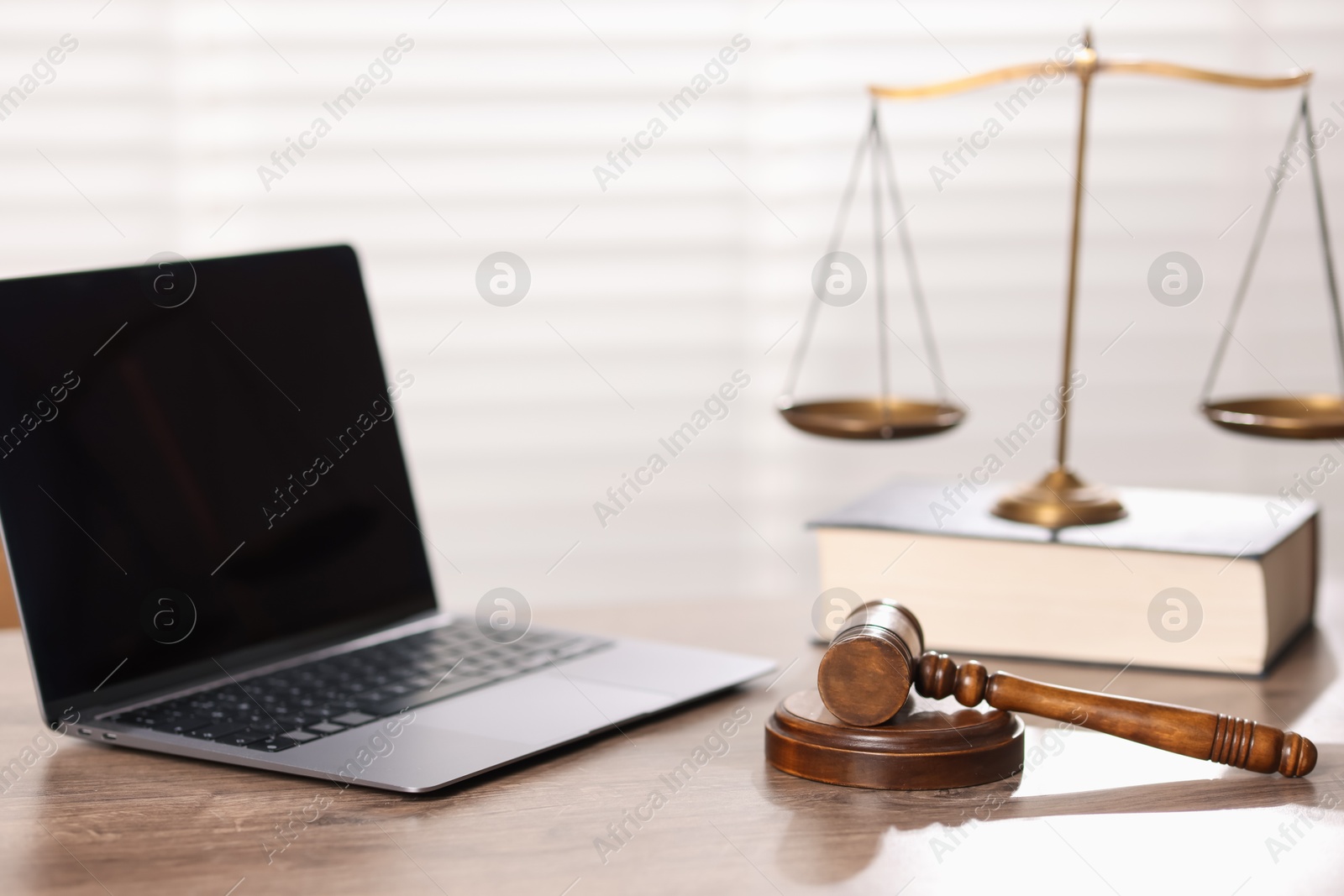 Judge. Laptop, gavel, scales and book on wooden table in office, selective focus Photo of Judge. Laptop, gavel, scales and book on wooden table in office, selective focus