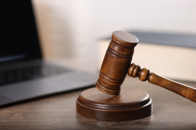 Photo of Judge. Laptop and gavel on wooden table in office, closeup
