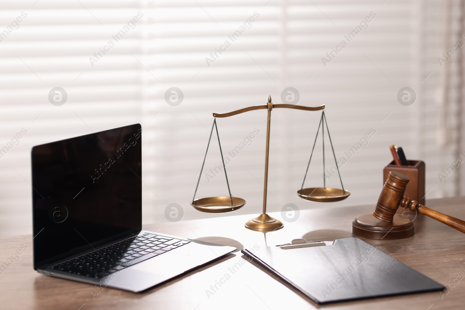 Judge. Laptop, gavel, scales and clipboard on wooden table in office Photo of Judge. Laptop, gavel, scales and clipboard on wooden table in office