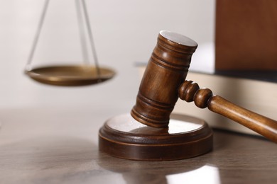 Photo of Judge. Gavel and scales on wooden table in office, closeup