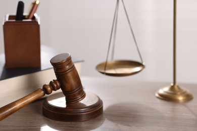Photo of Judge. Gavel and scales on wooden table in office, closeup