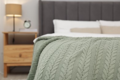 Photo of Color woolen blanket on bed indoors, closeup