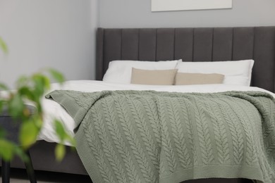Photo of Green woolen blanket on bed in room