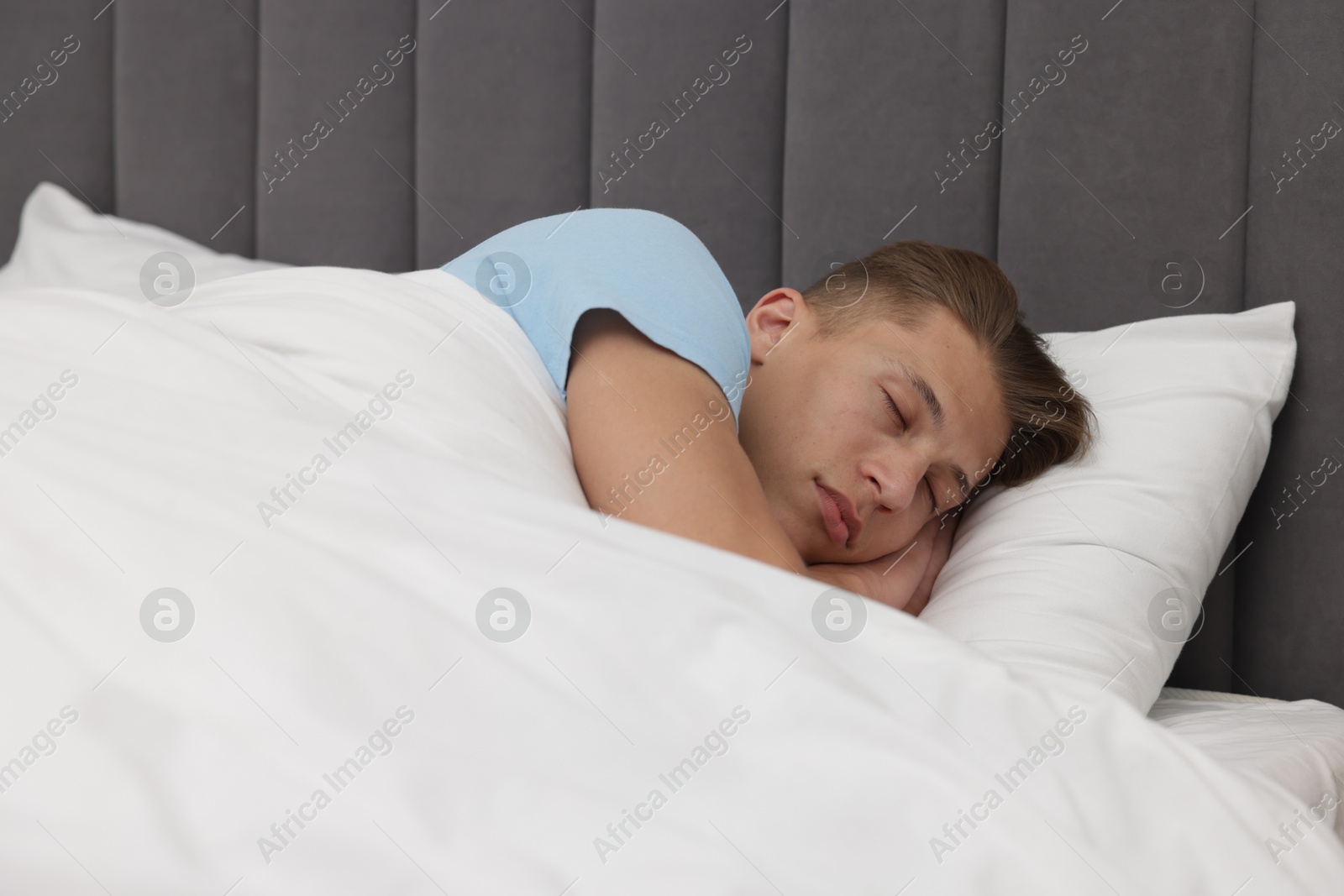 Man sleeping in comfortable bed at home Photo of Man sleeping in comfortable bed at home