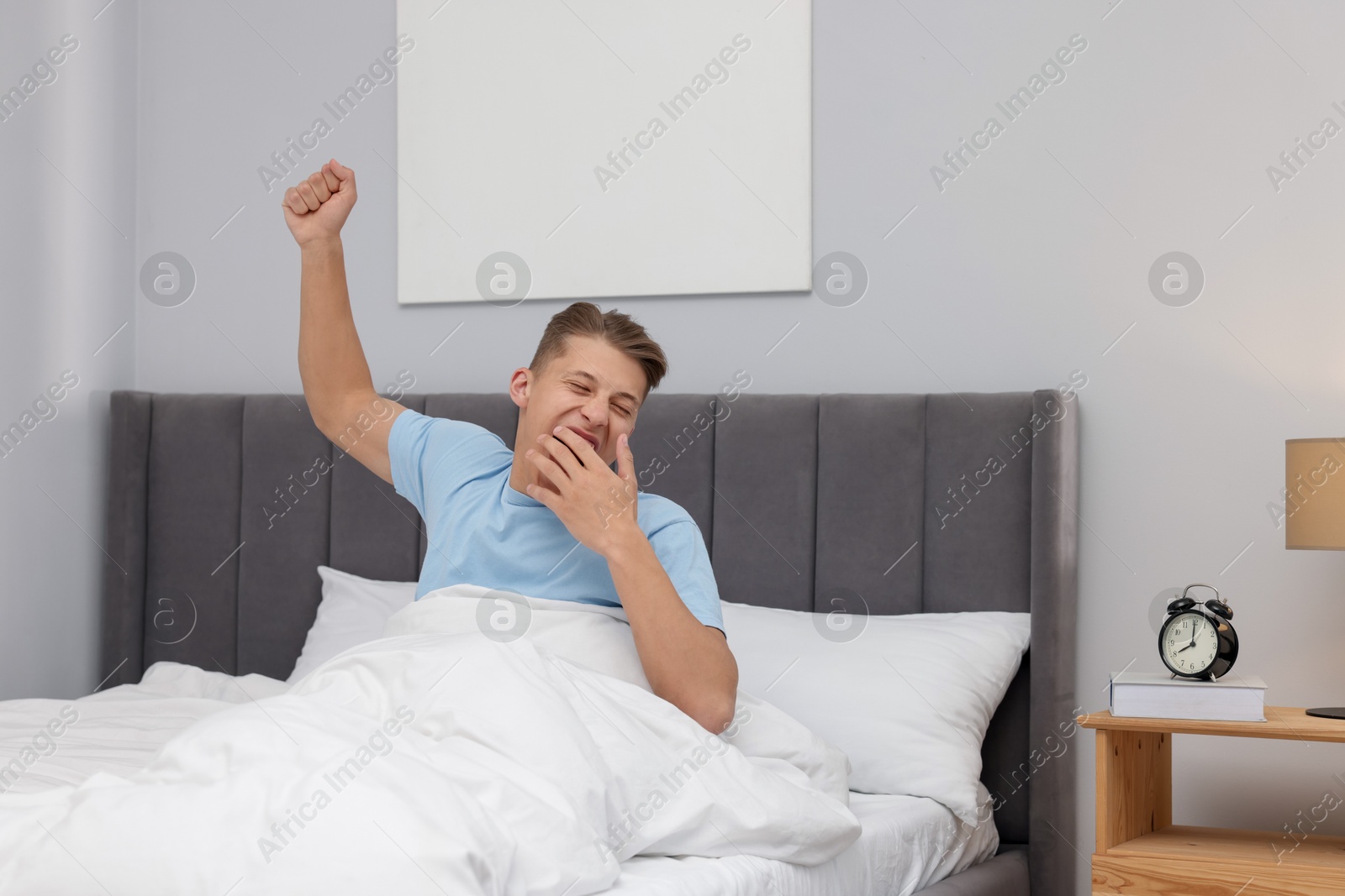 Man stretching in comfortable bed at home Photo of Man stretching in comfortable bed at home