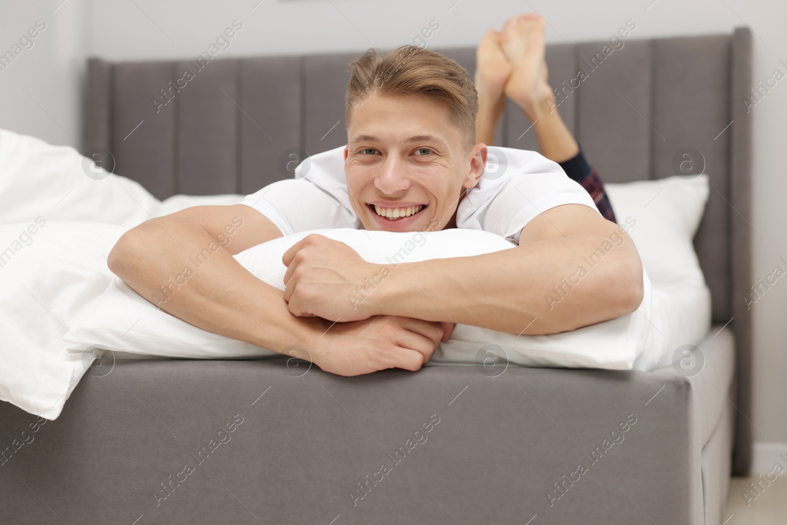 Happy man lying on comfortable bed at home Photo of Happy man lying on comfortable bed at home