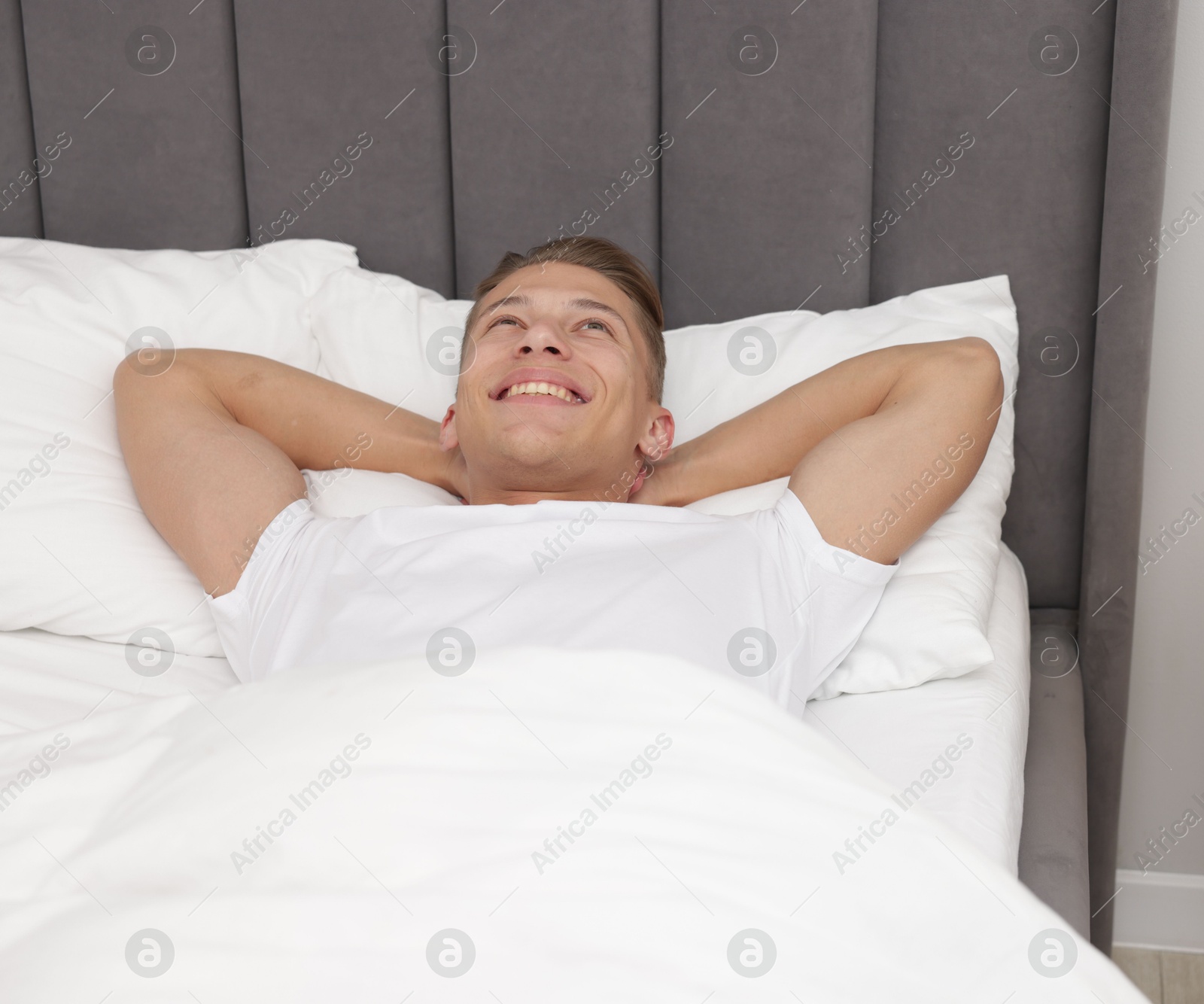 Man lying in comfortable bed at home Photo of Man lying in comfortable bed at home