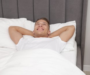 Photo of Man lying in comfortable bed at home