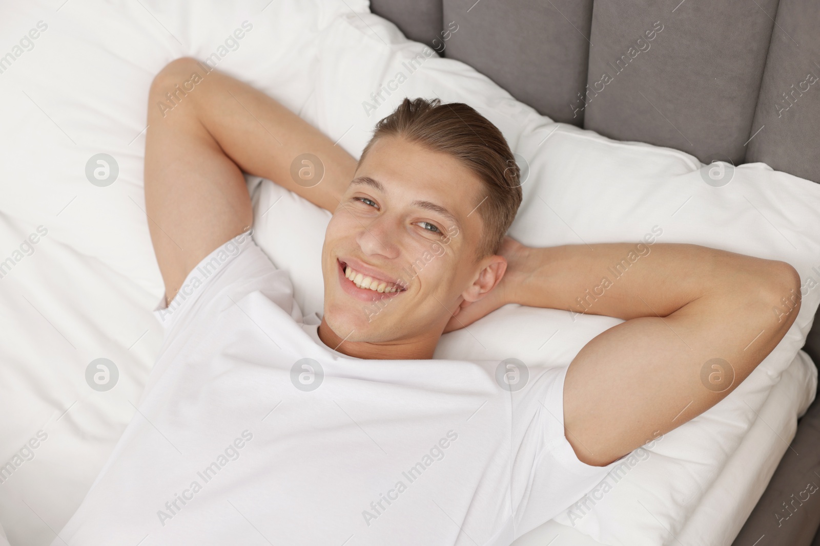 Man lying in comfortable bed at home, above view Photo of Man lying in comfortable bed at home, above view