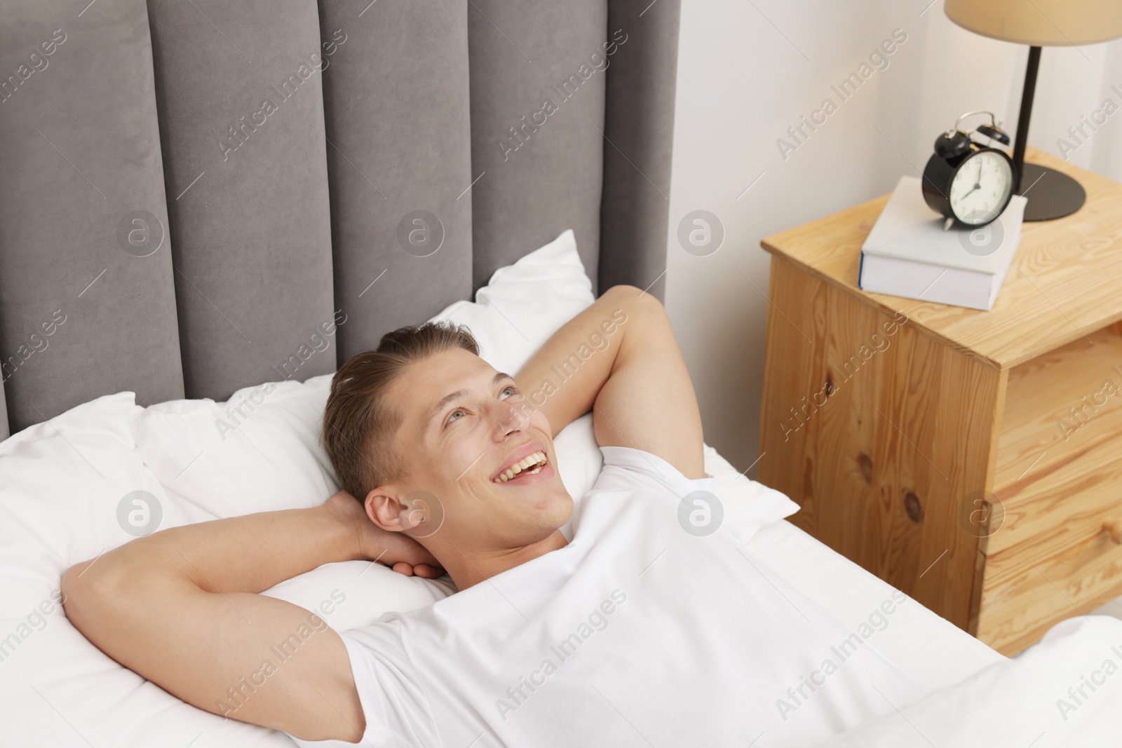 Man lying in comfortable bed at home Photo of Man lying in comfortable bed at home