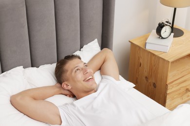 Photo of Man lying in comfortable bed at home