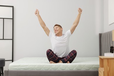 Photo of Man stretching on soft mattress at home