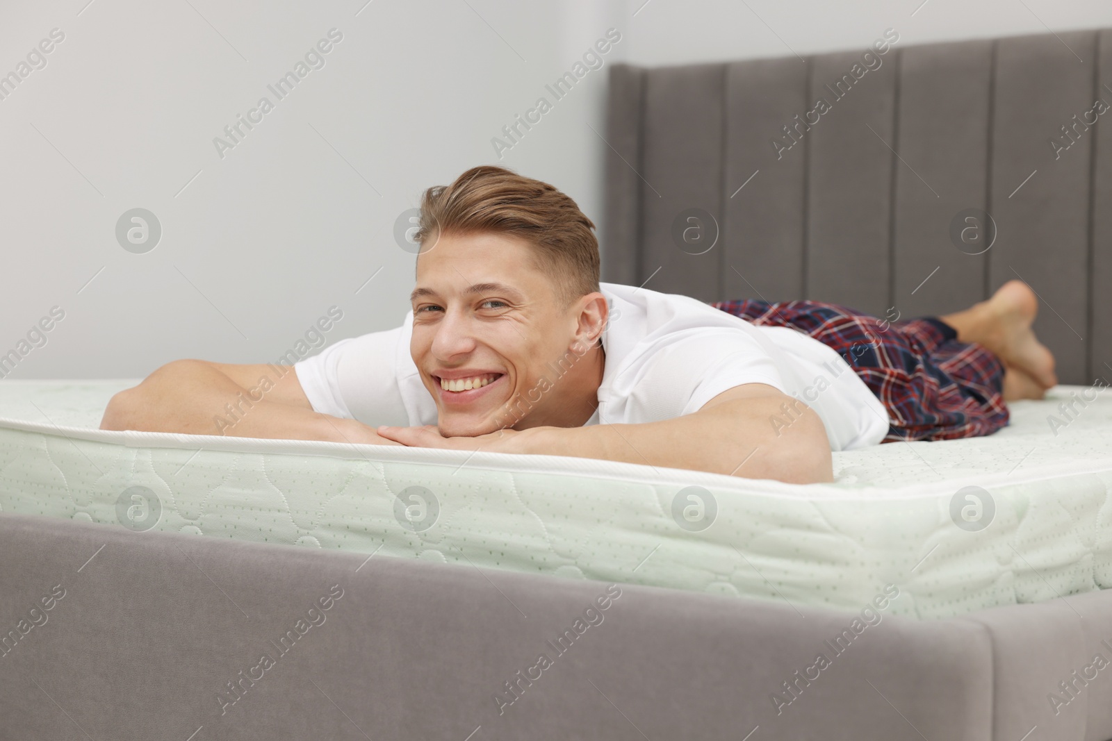 Happy man lying on soft mattress at home Photo of Happy man lying on soft mattress at home