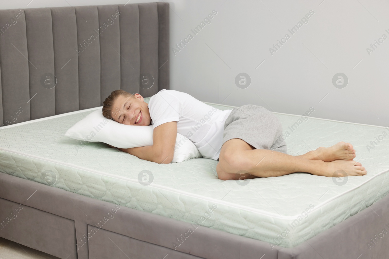 Happy man lying on soft mattress at home Photo of Happy man lying on soft mattress at home