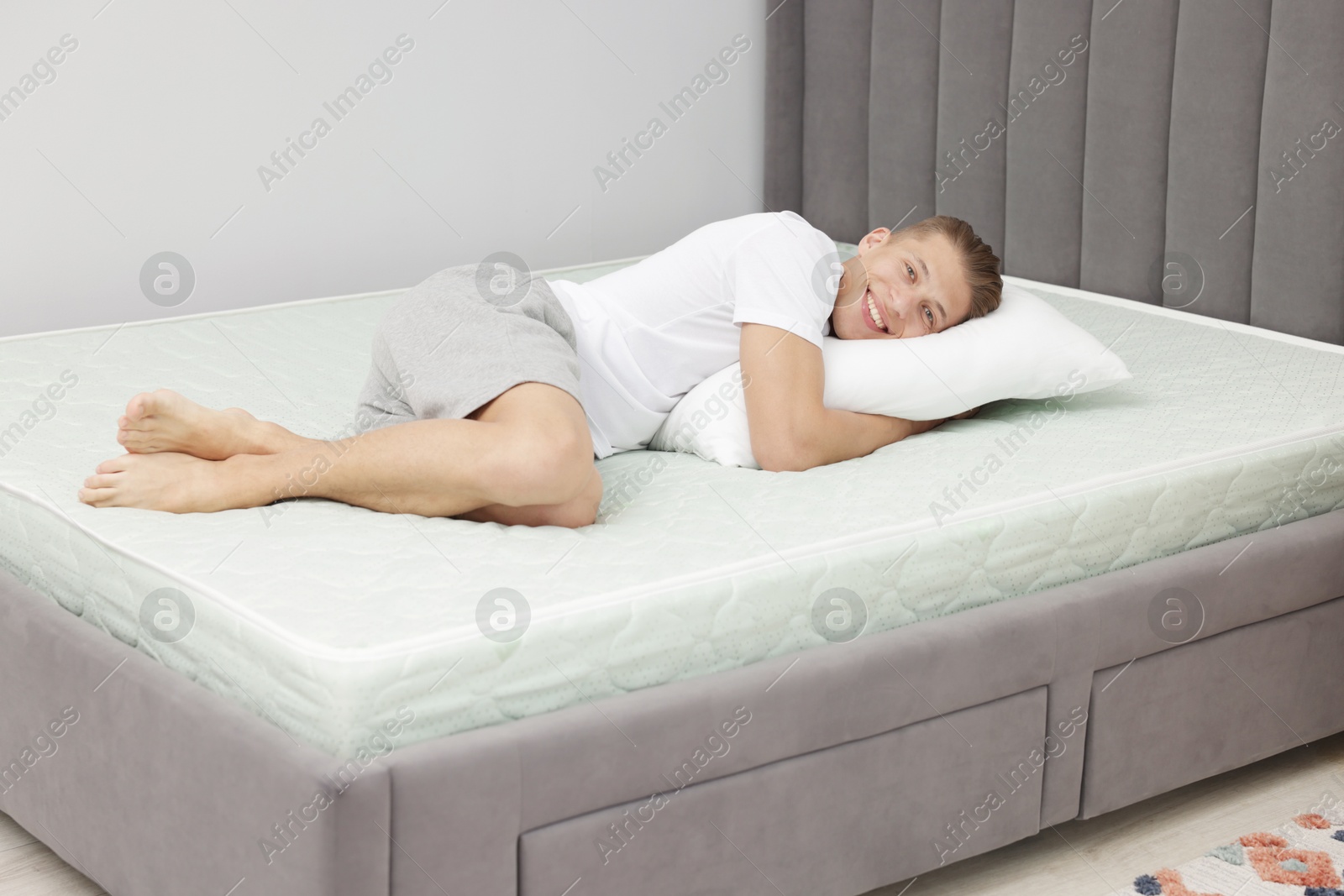 Happy man lying on soft mattress at home Photo of Happy man lying on soft mattress at home