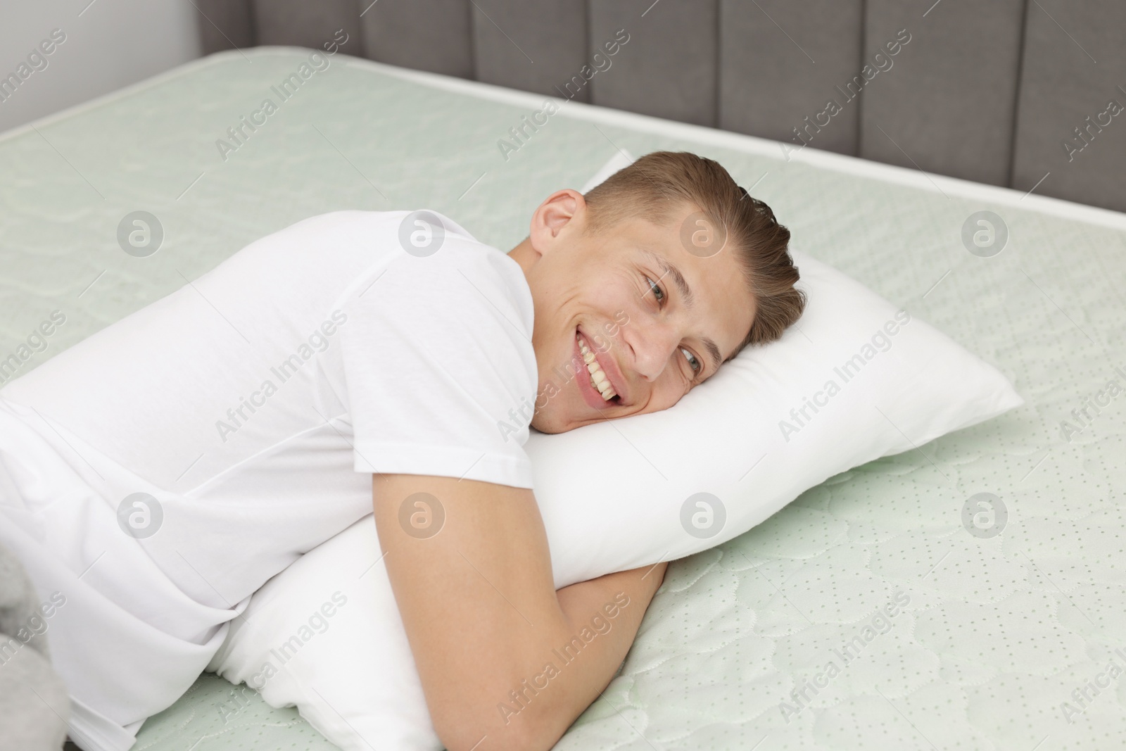 Happy man lying on soft mattress at home Photo of Happy man lying on soft mattress at home