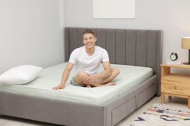 Photo of Man sitting on soft mattress at home