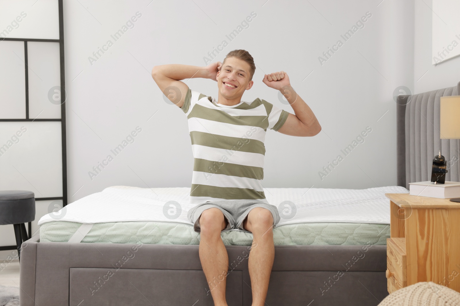 Man sitting on soft mattress at home Photo of Man sitting on soft mattress at home