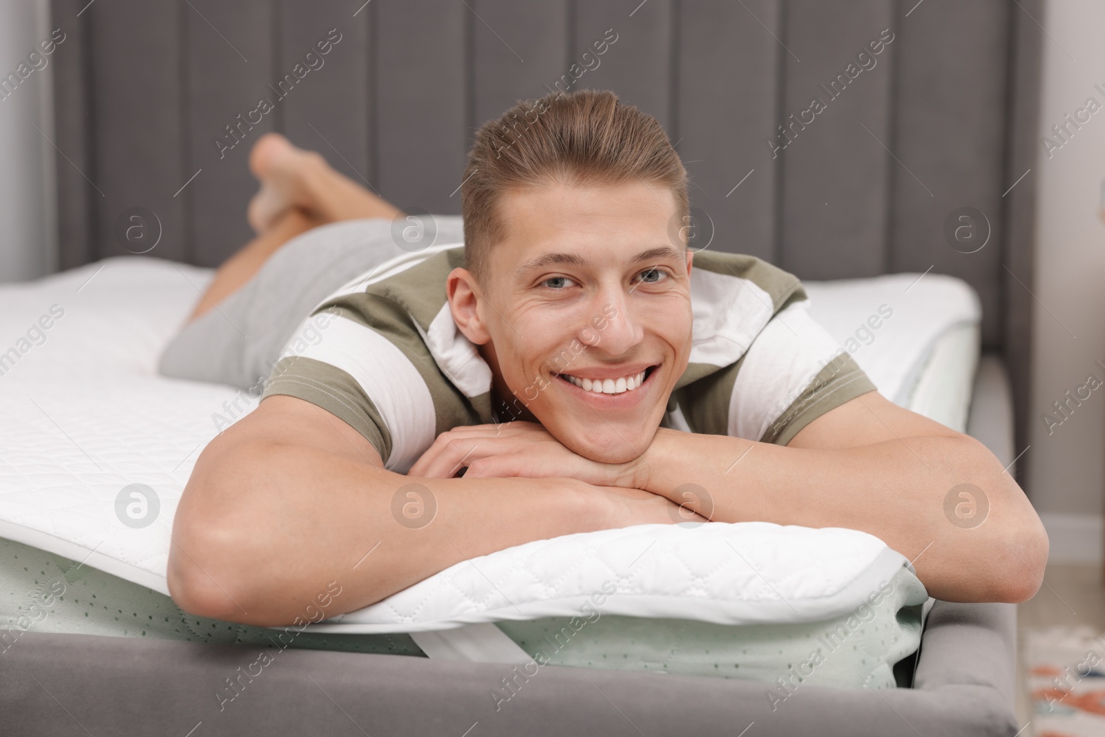 Man lying on soft mattress at home Photo of Man lying on soft mattress at home