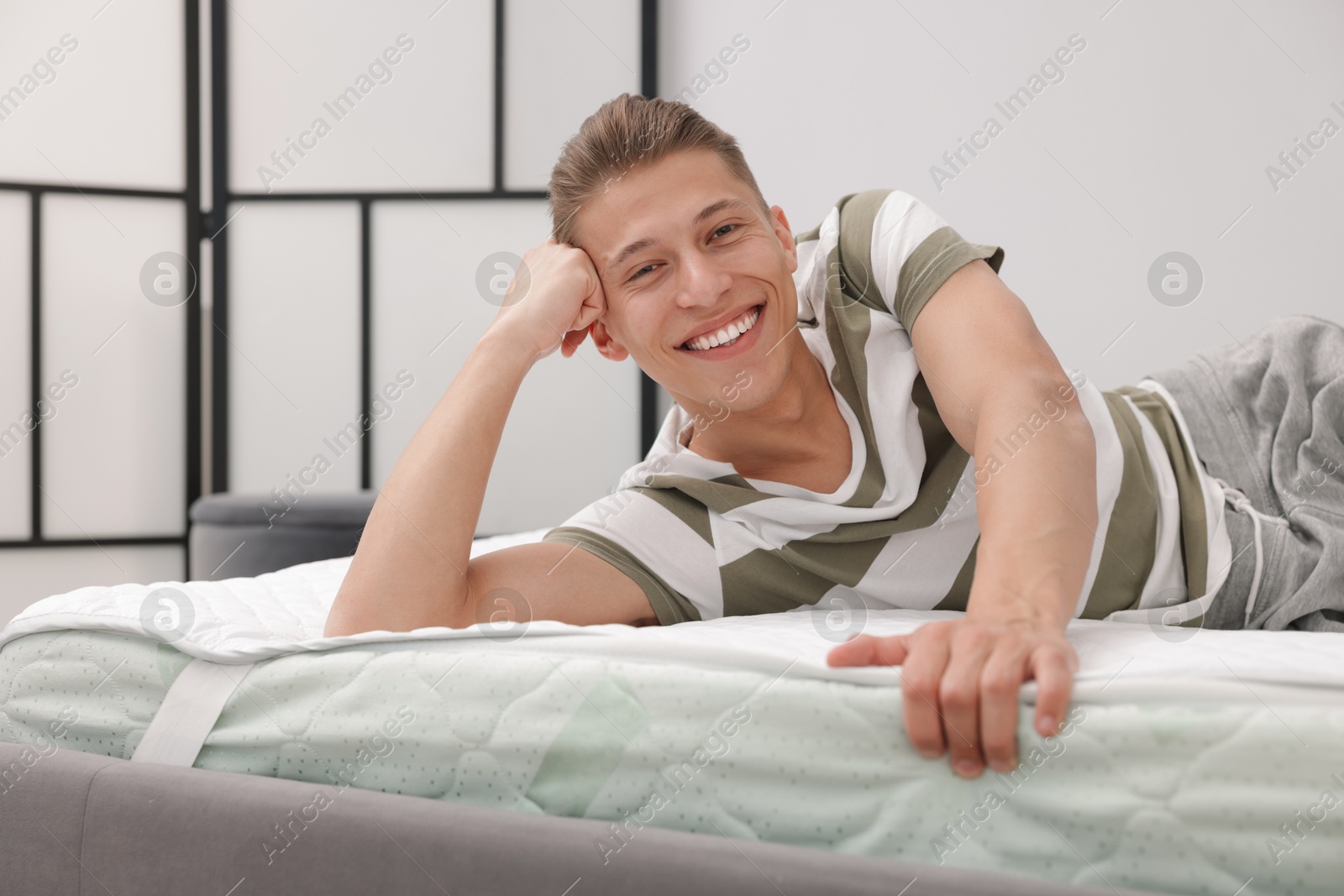 Man lying on soft mattress at home Photo of Man lying on soft mattress at home