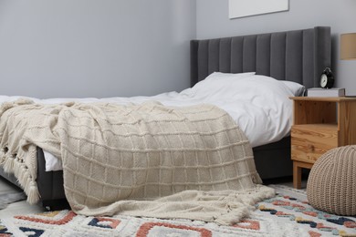 Photo of Beige woolen blanket on bed in room
