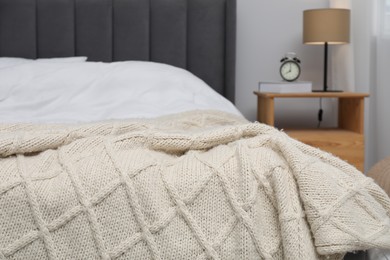 Photo of Woolen blanket on bed in room, closeup
