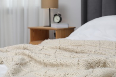 Photo of Woolen blanket on bed in room, closeup