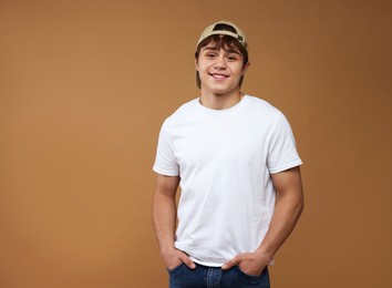 Photo of Portrait of teenage boy on brown background