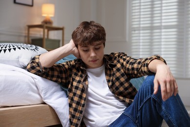 Photo of Teen problems. Upset teenage boy on floor at home