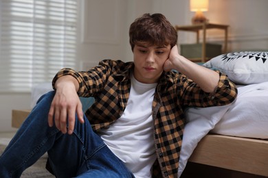 Photo of Teen problems. Upset teenage boy on floor at home