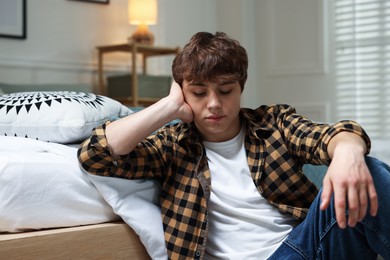 Photo of Teen problems. Upset teenage boy on floor at home