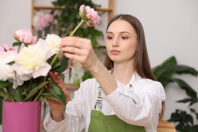 Photo of Florist making bouquet of peonies in flower shop