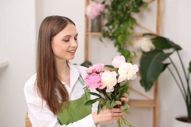 Photo of Florist with bouquet of peonies in flower shop