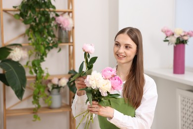 Photo of Florist making bouquet of peonies in flower shop, space for text