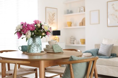Photo of Dining table with beautiful flowers and dishware in room, space for text. Interior design