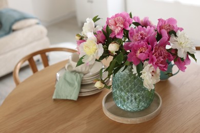 Photo of Dining table with beautiful flowers and dishware indoors, closeup. Interior design