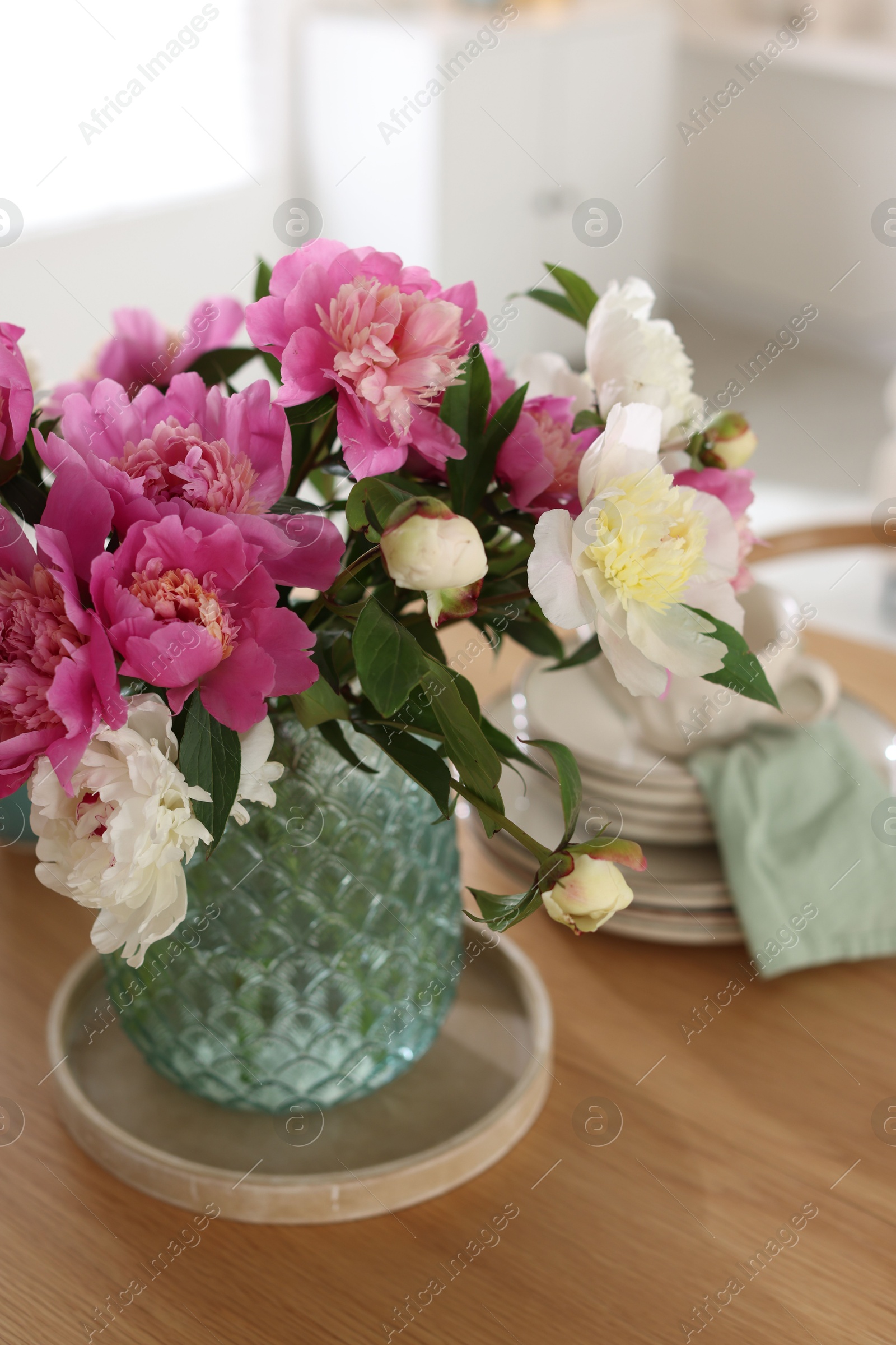 Dining table with beautiful flowers and dishware indoors, closeup. Interior design Photo of Dining table with beautiful flowers and dishware indoors, closeup. Interior design