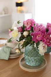 Photo of Dining table with beautiful flowers and dishware indoors, closeup. Interior design