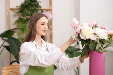 Photo of Florist making bouquet of peonies in flower shop