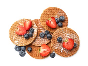 Photo of Tasty Dutch waffles (stroopwafels) and berries isolated on white, top view