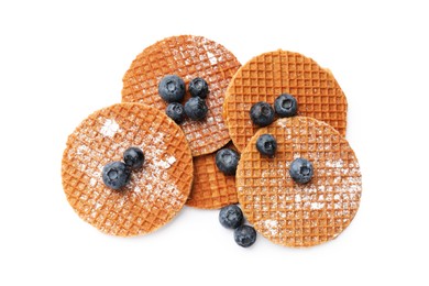 Photo of Tasty Dutch waffles (stroopwafels) and blueberries isolated on white, top view